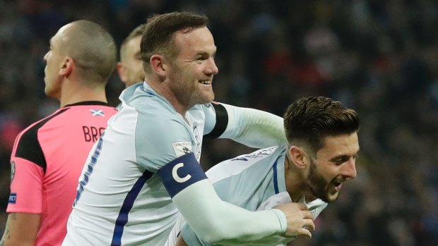 Big win: Adam Lallana celebrates with captain Rooney after England's third goal.