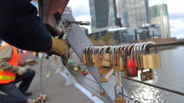 Council workers remove locks over the Yarra on Thursday. 