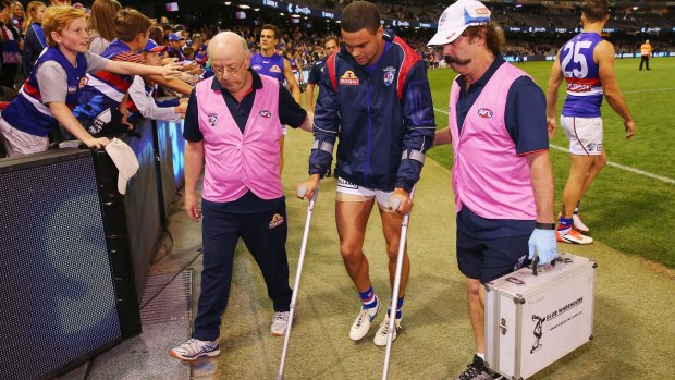 Jason Johannisen of the Bulldogs hobbles off on crutches after Saturday's game.