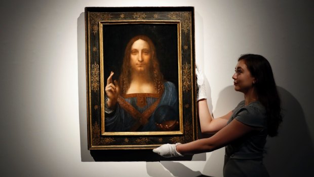 An employee with Leonardo da Vinci's Salvator Mundi on display at Christie's auction rooms, in London, before the auction.