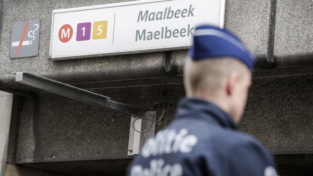 A Belgian police officer stands at the entrance to Maalbeek metro station in Brussels on Wednesday.