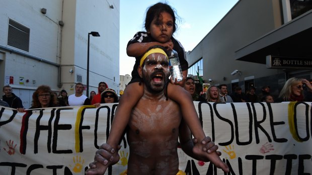 Stedman Sailor, 28, carrying his daughter Sharon Lawrence, 4, on his shoulders at the head of the protest.