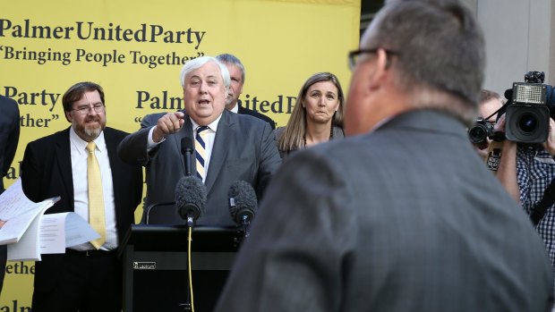 PUP leader Clive Palmer exchanges words with government whip Ewen Jones during a press conference at Parliament House on Thursday.