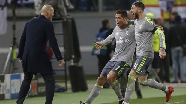 Real Madrid's Cristiano Ronaldo, celebrates with coach Zinedine Zidane, , and Sergio Ramos after scoring the opening goal.