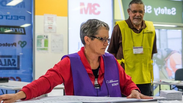 Staff and scrutineers taking part in the counting of votes in the AEC centre in Rockhampton.