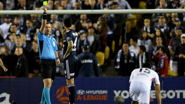 Victory's Rhys Williams is shown a yellow card at Etihad Stadium.