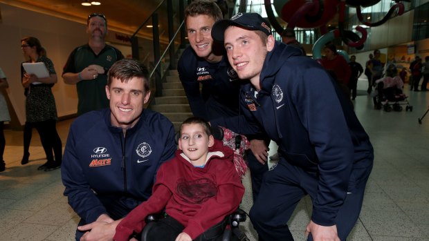 Carlton footballers Cameron Wood, Lachie Henderson and Ciaran Byrne visit Connor Oregan at the Royal Children's Hospital.