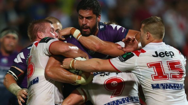 Jesse Bromwich of the Storm is gang-tackled during the match against St George Illawarra.