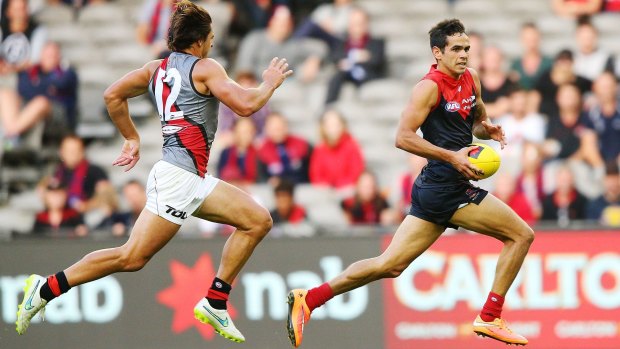 Melbourne’s Jeff Garlett, who booted four goals, sprints past Mark Baguley. 