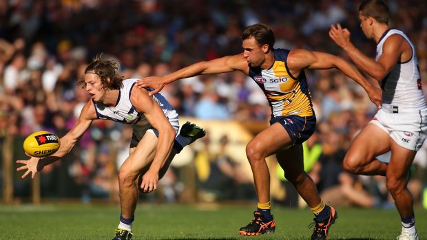 Nat Fyfe of the Dockers gathers a low ball before Dom Sheed of the Eagles has a chance to get to it.