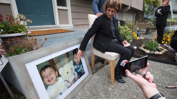 Teema Kurdi touches a photo of her nephews outside her home in Coquitlam, Canada, on Thursday.