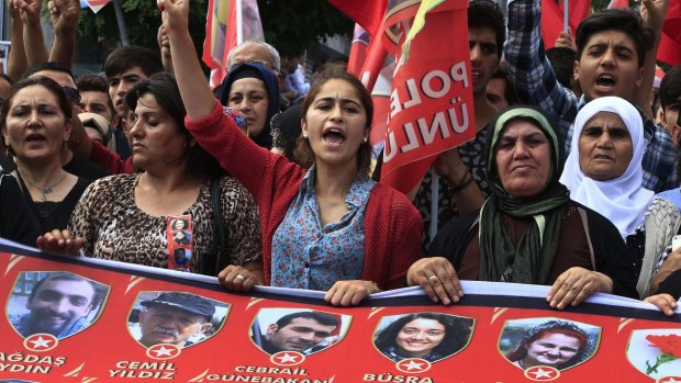 Mourners chant slogans as they carry a banner with pictures of 32 victims of an explosion on Monday in Suruc, southeastern Turkey,  during a protest in Istanbul. The suicide attack has been blamed on Islamic State.