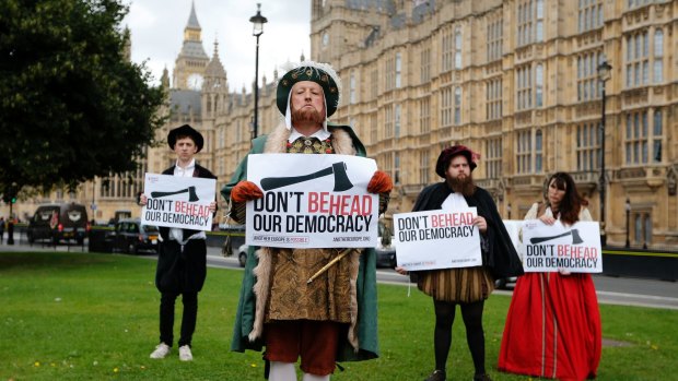 A protester dressed as Henry VIII with an entourage of Tudors demonstrates outside Parliament in Westminster.