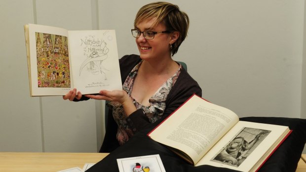 Researcher Michelle Hughes with items accompanying the Waterhouse artworks at the National Archives of Australia in Canberra, including a book excerpt about Mollie the smoking orang-utan.