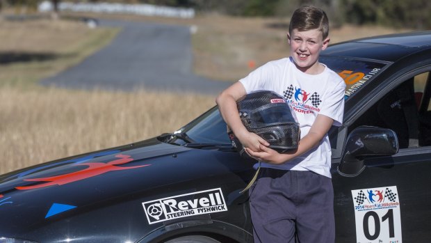 Thomas Henderson-Smith,10, with HeartKids hillclimb organiser Dan Cummin's race car.