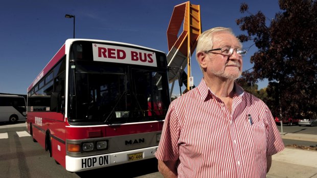 The Red Explorer Bus operator, John Williams, with his bus at the National Museum of Australia.