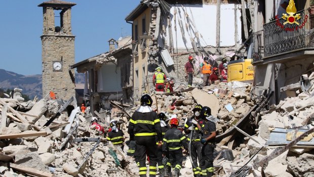 Rescuers work amid collapsed buildings in Amatrice.