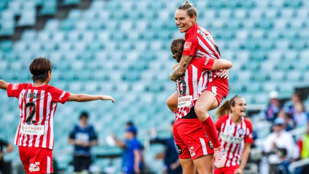 Hero's embrace: Jessica Fishlock (centre) celebrates after Melbourne City win the 2018 W-League grand final at Allianz Stadium.