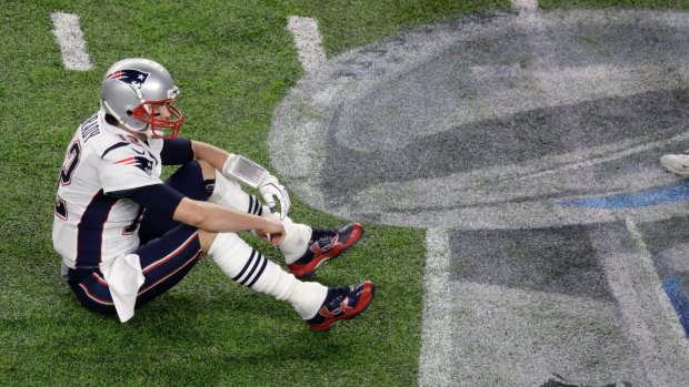 Deflated: Patriots quarterback Tom Brady sits on the field after fumbling against the Eagles during the second half.