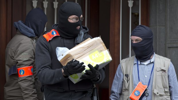 Belgian police leave after an investigation in a house in the Anderlecht neighbourhood in Brussels.