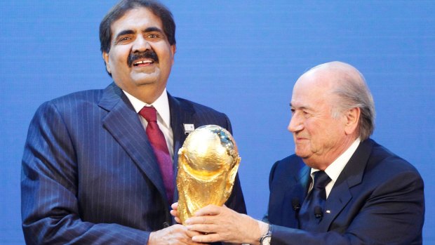 Sheikh Hamad bin Khalifa Al-Thani, Emir of Qatar (left) is presented with the World Cup trophy by former FIFA president Sepp Blatter after being awarded hosting rights for the 2022 tournament.