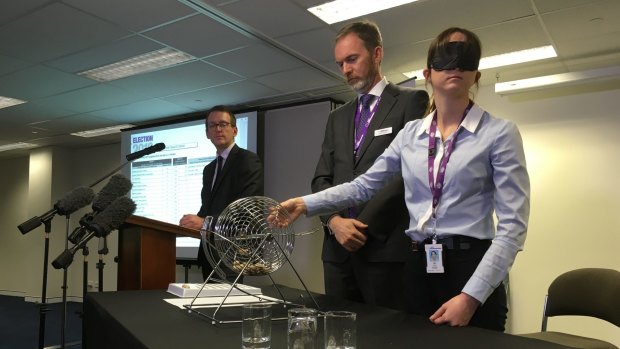 Australian Electoral Commission officials conduct the draw for the Queensland Senate ballot paper.