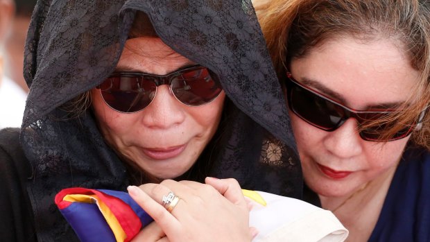Leslie Abad, left, the widow of First Lieutenant Raymond Abad of the Philippine marines, at his buria.  Abad was one of 13 marines killed on June 9 in fighting between government forces and Muslim militants in Marawi.