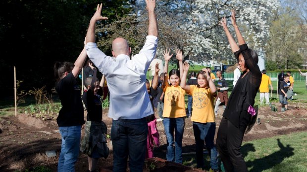 First lady Michelle Obama, right, leads a "grow dance" after working in the garden at the White House with school children in 2010.