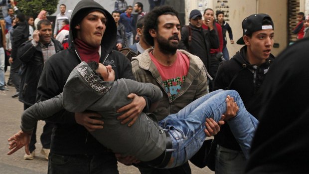 Anti-government protesters carry a wounded protester through the streets of Cairo on Sunday.