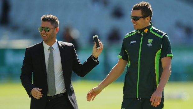 All dressed up for his role as commentator, Michael Clarke talks to Peter Siddle before the start of the Boxing Day Test.