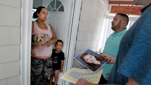 Detectives Timothy Callinan, far right, and Wayne Carter, speak with Andrea Mesa and her son Anthony, as they follow up on a tip that a child similar to Baby Doe was seen in a nearby park in Winthrop, Massachusetts. 