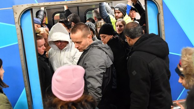 Passengers try to squeeze aboard a packed train during Thursday's rail meltdown.