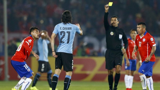 Victim: Uruguay's Edinson Cavani, centre, gestures to referee Sandro Riccias as Chile's Gonzalo Jara looks on.