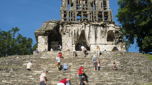 Visitors clamber up the Templo del Sol in Palenque.