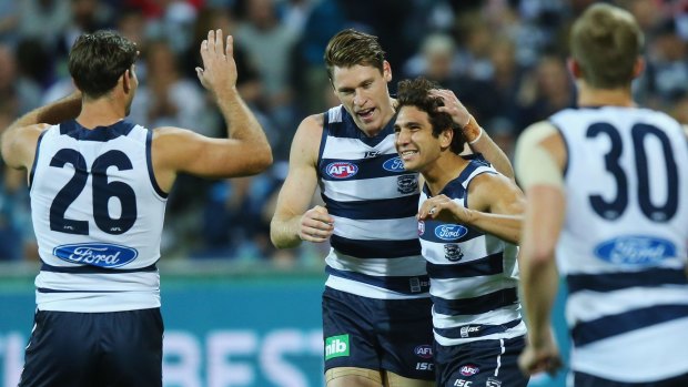 Nakia Cockatoo of the Cats celebrates a goal with Tom Hawkins (left) and Mark Blicavs.