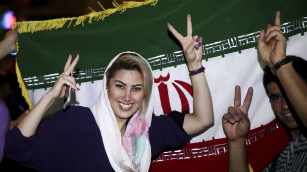An Iranian woman shows the victory sign as people celebrate the nuclear deal in Tehran on Tuesday.