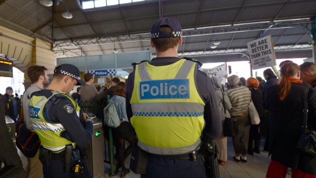 Police watch as protesters rally inside Flinders Street Station on Friday against    Australian Border Force officers taking part in Operation Fortitude.