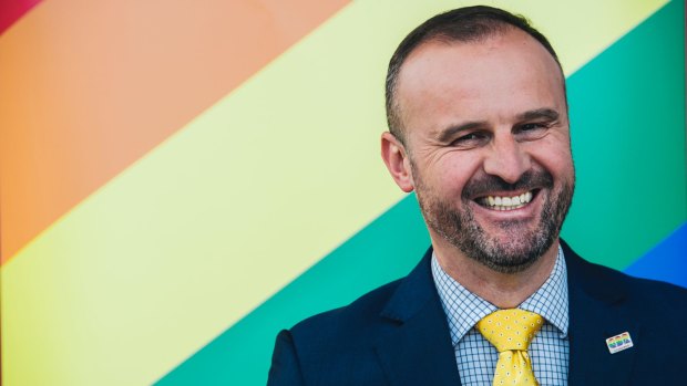 ACT Chief Minister Andrew Barr talks about the government's support for same-sex marriage in Australia in front of a rainbow banner.