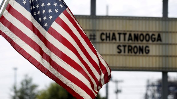 An American flag flies alongside a sign in honour of the four Marines shot and killed in Chattanooga, Tennessee in July.