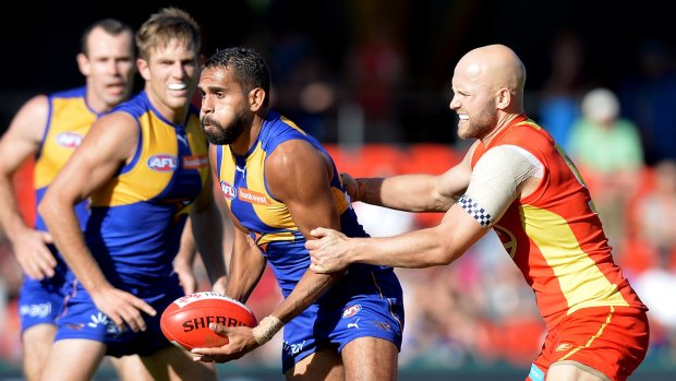 West Coast's Lewis Jetta is pressured by Gary Ablett, who starred for the Suns.