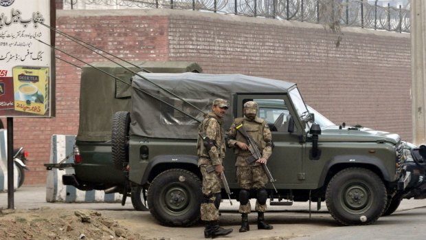 Pakistani soldiers stand guard outside the Faisalabad prison as an execution of convicted militants takes place.