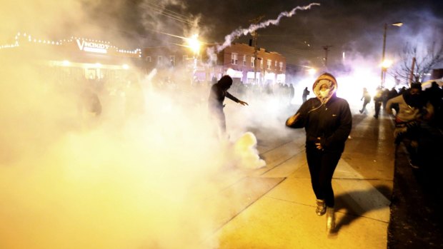 Protesters run from a cloud of tear gas in Ferguson.