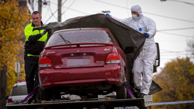 Police tow a car from the Brighton apartments on Bay Street on Tuesday.