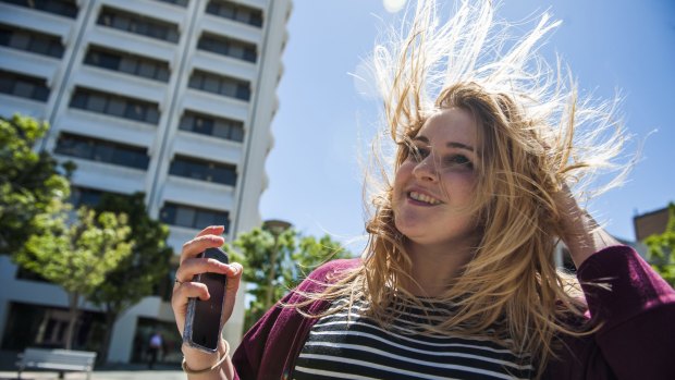 Laura Corrigan of Holder tries to tame her hair in the wind in Woden Square