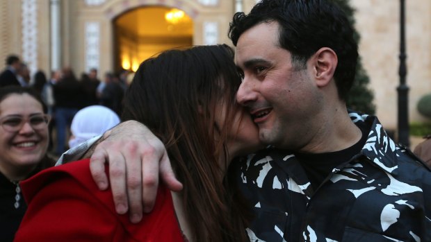 A released Lebanese policeman is kissed by his wife upon his arrival at the government palace in Beirut.