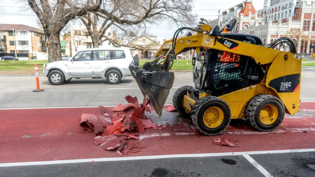 Workers removing damaged tarmac in the bus lane on Victoria Parade.