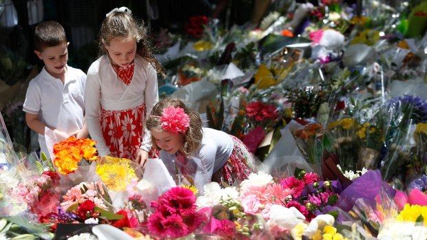 Three children leave a tribute to the victims of the siege in Martin Place. 