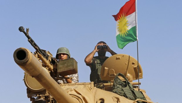 Kurdish fighters in Iraq man a tank on the front line against Islamic State south-west of the city of Mosul.