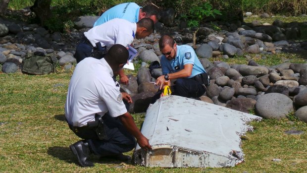 French police inspect the flaperon, now confirmed to be from MH370, on Reunion Island.