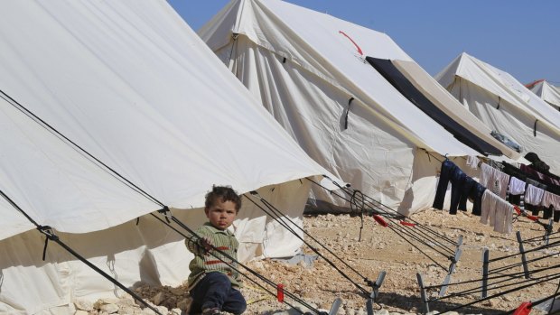 A child plays around a temporary refugee camp for displaced Syrians in northern Syria.